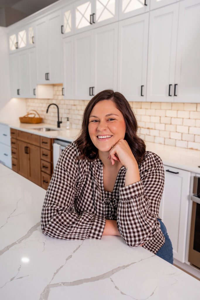 Caitlyn Sullivan smiling, leaning on a marble kitchen counter